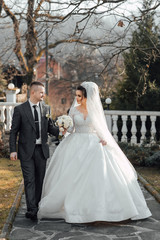 Happy couple celebrating their wedding outdoors. Stylish beautiful couple of happy newlyweds on a walk on their wedding day