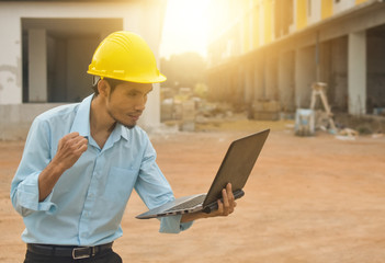 Professional engineer construction holding computer hard hat building estate site