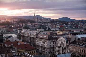 Fototapeta premium sunset over the roofs of Budapest during winter with fishermans bastion