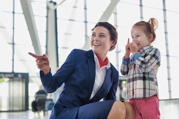 Portrait of airport staff playing with cute little girl in airport