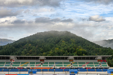 Stadium seats in the racetrack with fog on mountain