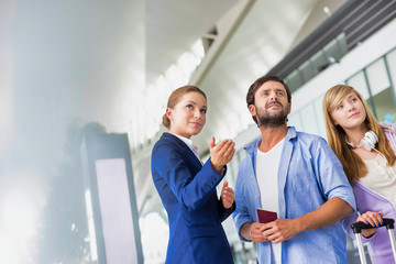 Mature man traveling with her sister while asking for assistance with the airport staff
