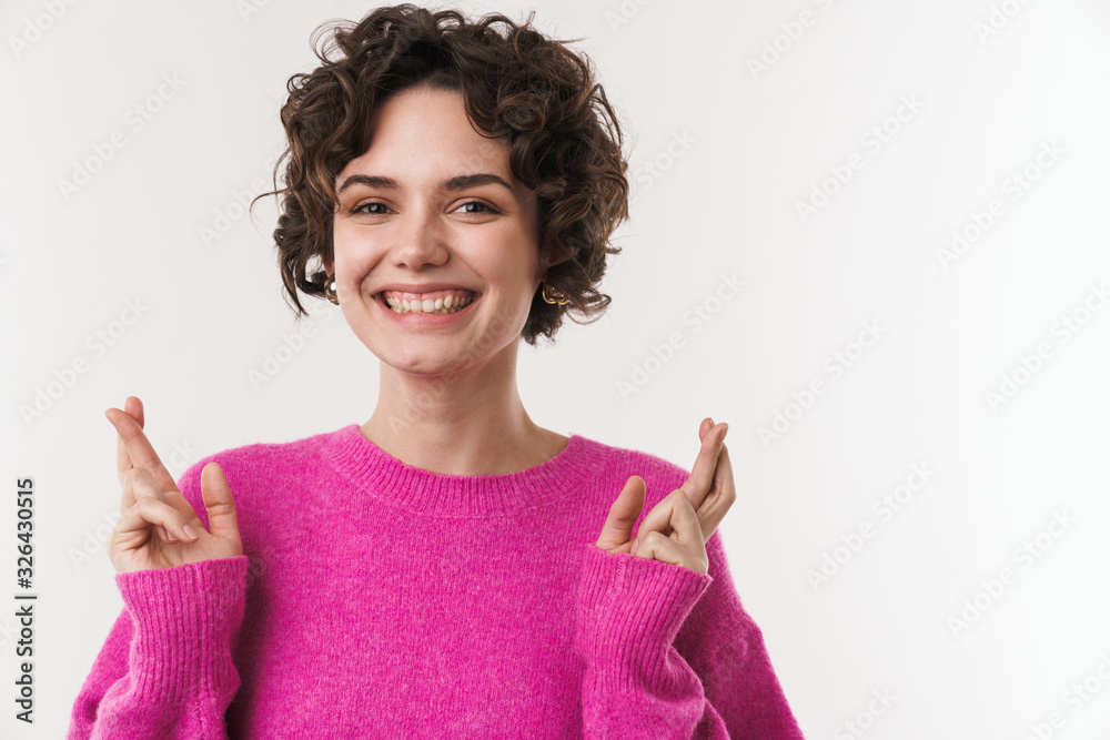 Poster Image of cheerful young woman holding fingers crossed and smiling