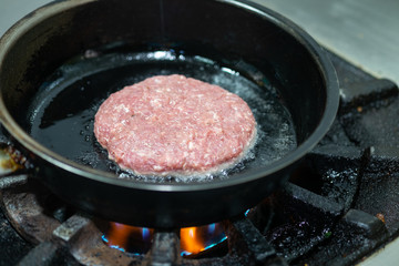 Beef burgers cooking in kitchen