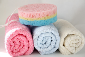 Piled towels and a washcloth for a shower. Body towel shower sponge.
