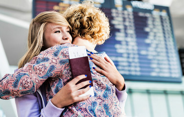 Young teenage girl reuniting with her mother in airport