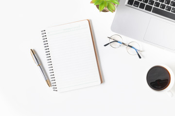 White office desk table Blank notebook with laptop computer