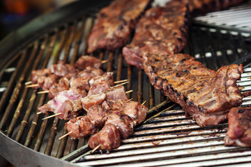 Grilled pork ribs on the grill. Street food background. Marinated pork spare ribs. Street market. Fresh grilled meat.