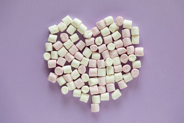 Heart shaped marshmallows on purple background