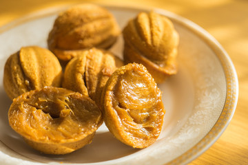 Small cookies in the form of walnuts on a white saucer.