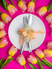 Easter table cutlery with tulips, feathers and bow