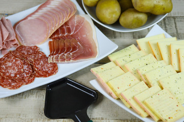 fromage à raclette et charcuteries dans une assiette