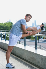 Portrait of young attractive man stretching his legs