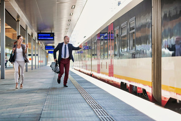Portrait of business people running to catch the train in station