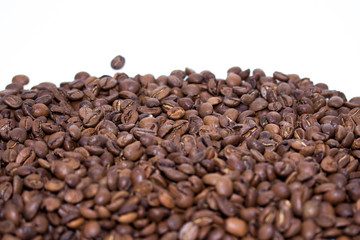 Roasted coffee beans pile isolated on white background. Selective focus.