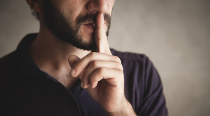 Man making silence gesture, shhh.