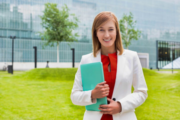 Portrait of young attractive businesswoman standing while holding document