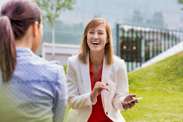 Businesswoman laughing while talking to her colleague