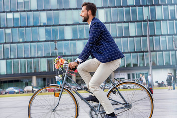 Portrait of young attractive businessman riding bicycle