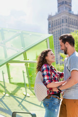 Portrait of young attractive couple standing while hugging each other in the middle of the city