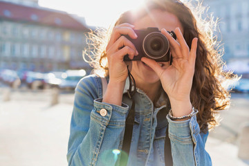 Young attractive woman holding camera and taking photo
