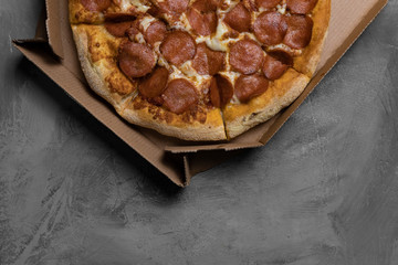 Food ingredients and spices for cooking mushrooms, tomatoes, cheese, onion, oil, pepper, salt, basil, olive and delicious italian pizza on black concrete background. Copyspace. Top view. Banner