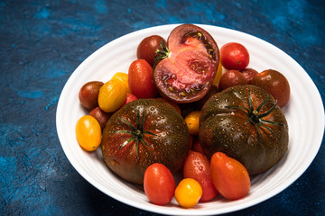 Vibrant Organic Tomatoes on Plate. Market Fresh Vegan Food. Plant Food Diet