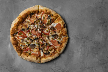 Food ingredients and spices for cooking mushrooms, tomatoes, cheese, onion, oil, pepper, salt, basil, olive and delicious italian pizza on black concrete background. Copyspace. Top view. Banner