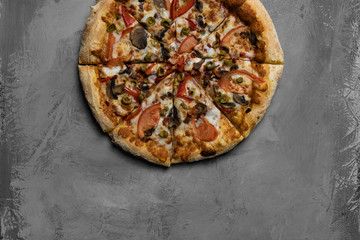 Food ingredients and spices for cooking mushrooms, tomatoes, cheese, onion, oil, pepper, salt, basil, olive and delicious italian pizza on black concrete background. Copyspace. Top view. Banner