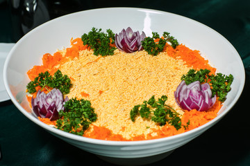 Mimosa canned fish salad layers in the shape of a circle with a portion. Angle view