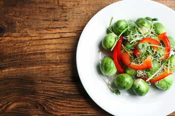 Tasty salad with Brussels sprouts on wooden table, top view. Space for text