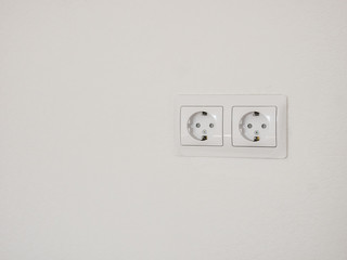 Modern white double socket on the wall. Household electrical equipment.