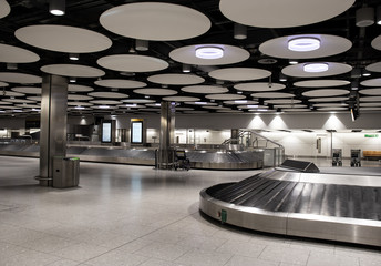 Empty baggage carousel conveyor at the baggage collection hall in Terminal, Heathrow Airport,...
