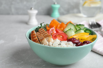 Tasty rice with beans and chicken meat on light grey marble table, closeup