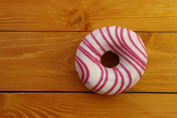 Fototapeta na wymiar Tasty donut on wooden background