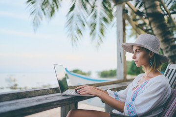 Technology and travel. Working outdoors. Freelance concept. Pretty young woman using laptop in cafe...