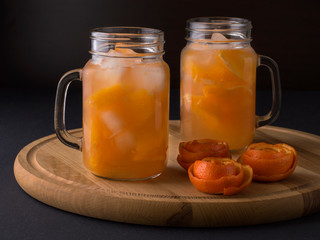 cooling drink tangerine juice with ice on the kitchen table.