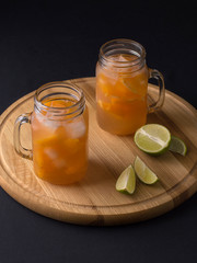 cooling drink tangerine juice with ice on the kitchen table.