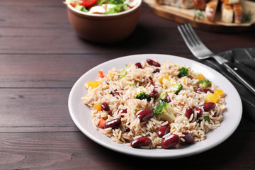 Delicious rice with beans served on wooden table
