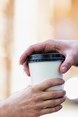 Close up photo of businesswoman giving businessman a cup of coffee