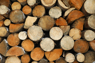 Stacked firewood with snow as background, closeup. Heating house in winter