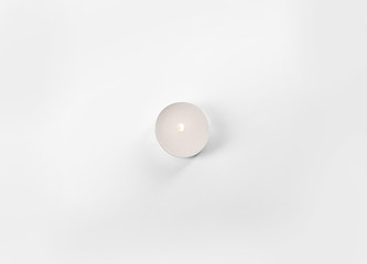 Burning tea candle isolated on white, top view