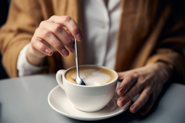 hand holding cup of coffee on black background