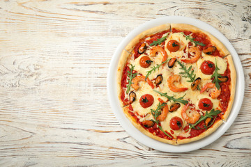 Delicious seafood pizza on white wooden table, top view. Space for text