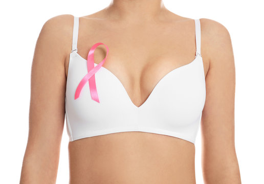 Woman with pink ribbon on white background, closeup. Breast cancer awareness