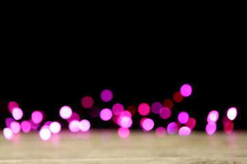 Blurred view of beautiful lights on black background. Bokeh effect