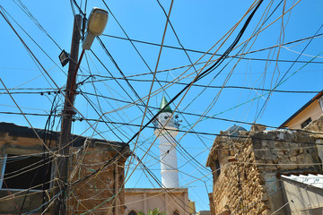 Power lines, a messy mess of power lines between houses in the ancient Phoenician city of Tyros in...