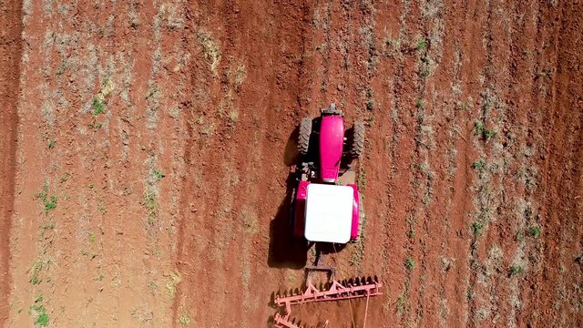 zenith Aerial drone view of tractor passing through the screen and preparing the soild for seed planting