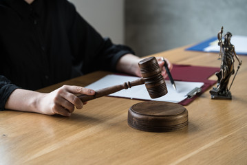 justice and law concept. Female judge in a courtroom on wooden table and Counselor or Male lawyer working in office. Legal law, advice and justice concept.