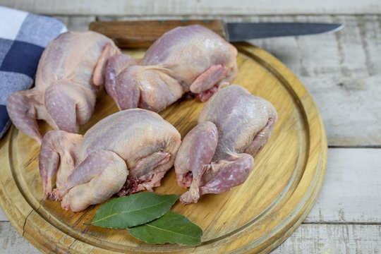 cailles crues sur une planche &agrave; d&eacute;couper